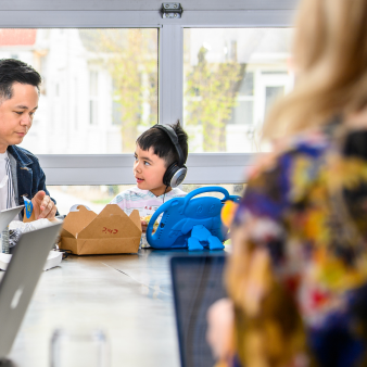 A Clockworker and their child seated together in our office having lunch