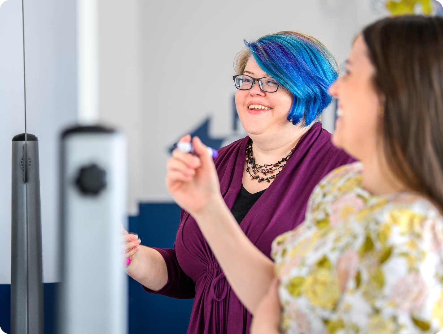 Two Clockworkers collaborating and problem solving on a whiteboard