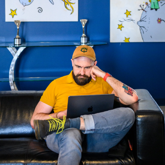 A concentrated Clockworker seated on an office couch while working