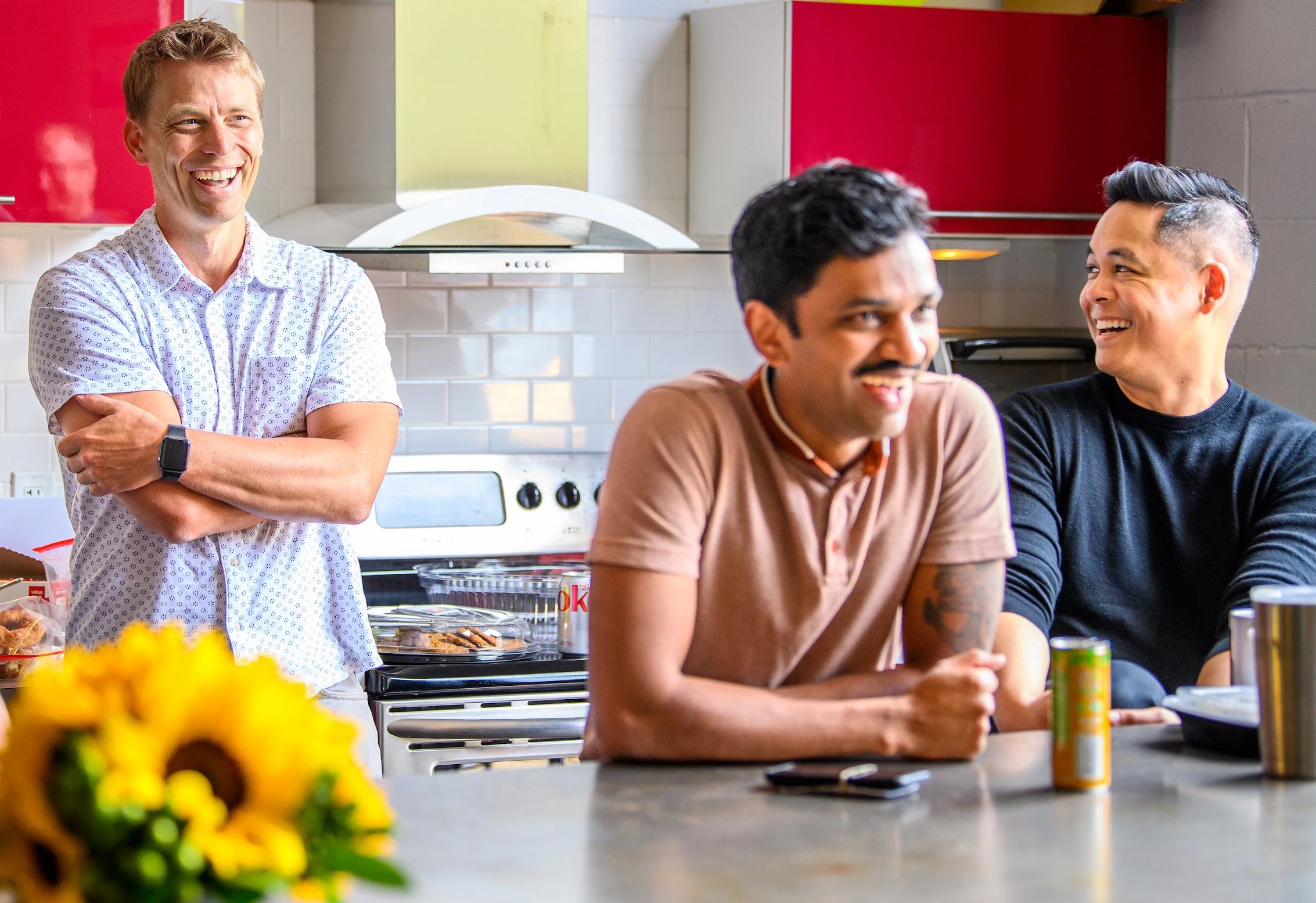 Three clockworkers smiling at our Rayvic kitchen table