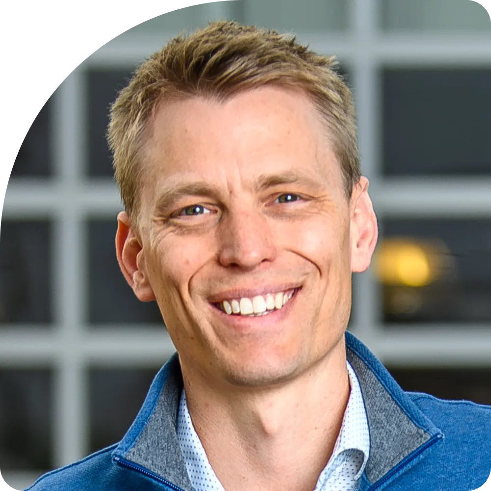 Luke Vestrum, Managing Director of Tempo. A smiling man with short light brown hair, wearing a blue jacket over a white shirt, stands in front of a blurred background with grid-like windows.